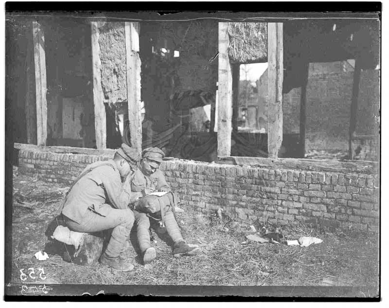 Arnaldo Garcez, Dois militares sentados junto a edifício estando um a escrever, 1917 ,0553